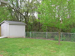 nice fenced in backyard with large storage shed.